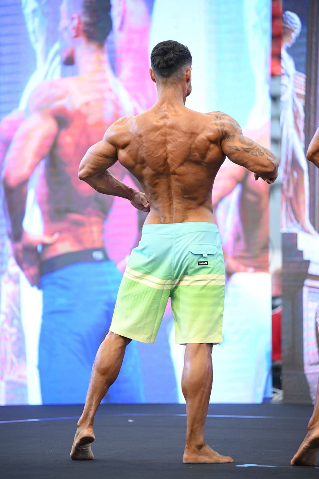Abel Higón en pose de competición IFBB, vista de espalda